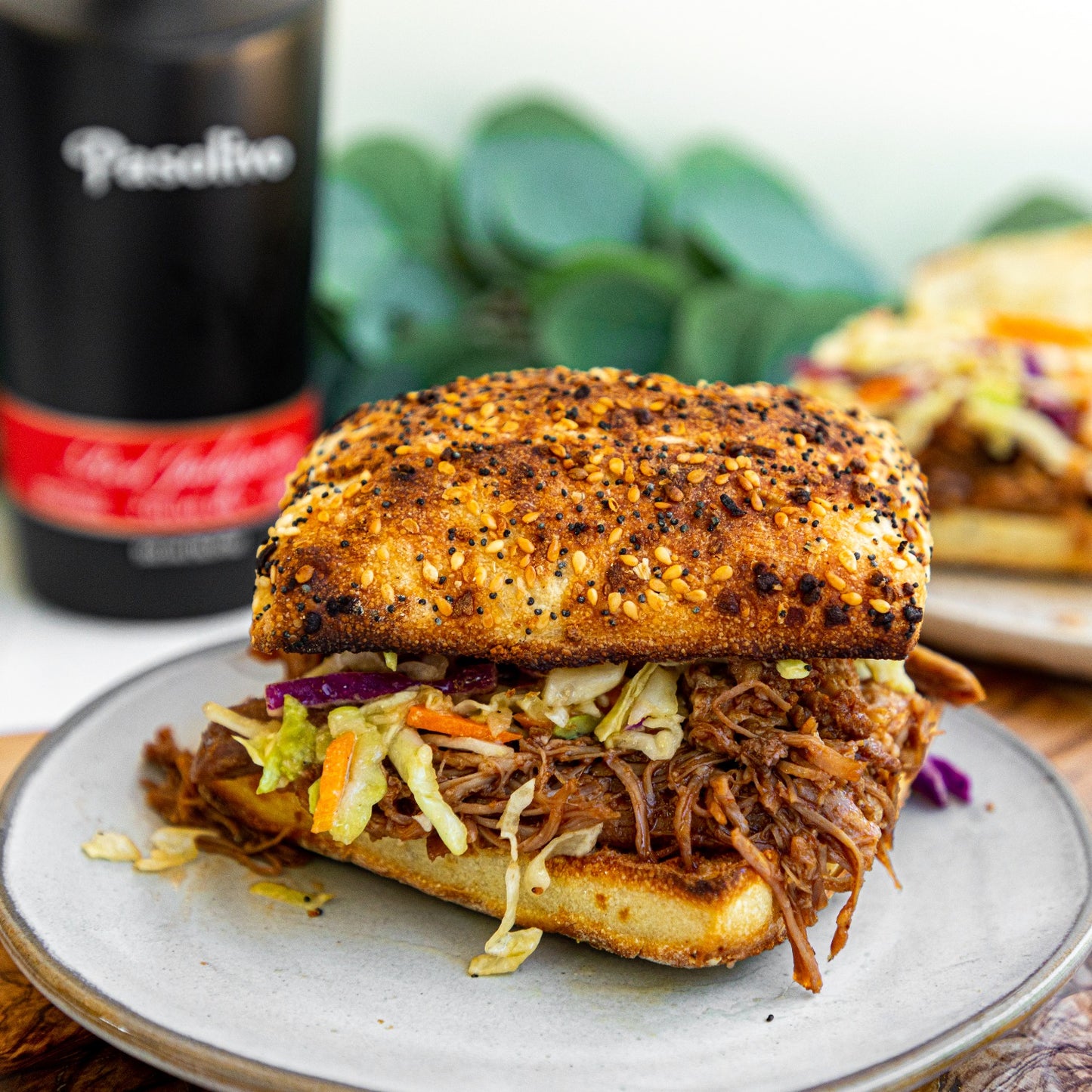 Pasolivo Red Jalapeno Pulled Pork Sandwich Recipe on table next to Pasolivo Red Jalapeno Olive Oil