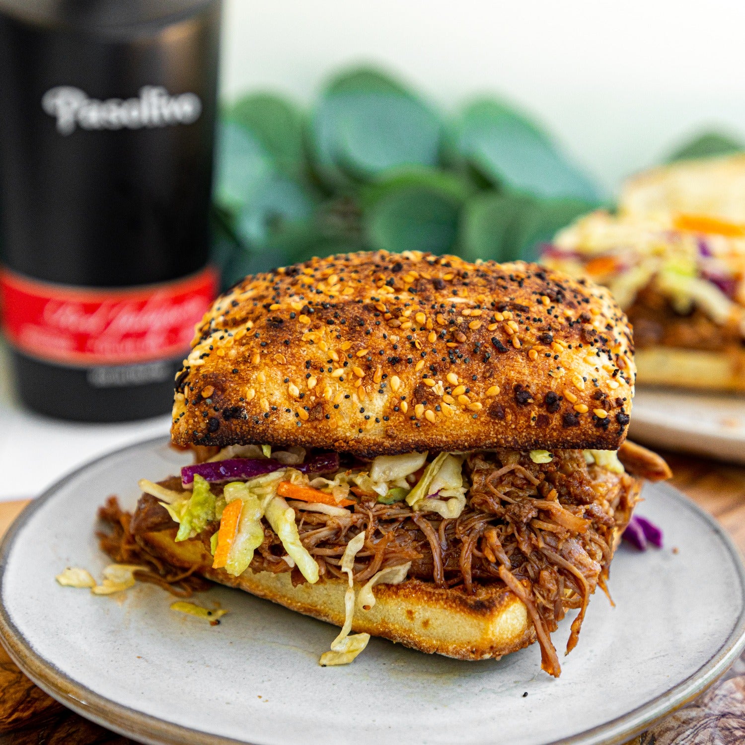 Pasolivo Red Jalapeno Pulled Pork Sandwich Recipe on table next to Pasolivo Red Jalapeno Olive Oil