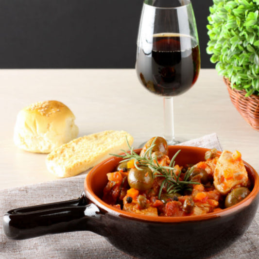 Pasolivo Oven-Roasted Chicken Cacciatore Recipe next to bread and a glass of wine and garnished with rosemary