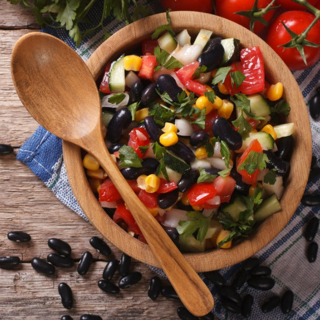 Pasolivo Lime Black Bean Salsa Recipe next to tomatoes and a wooden spoon