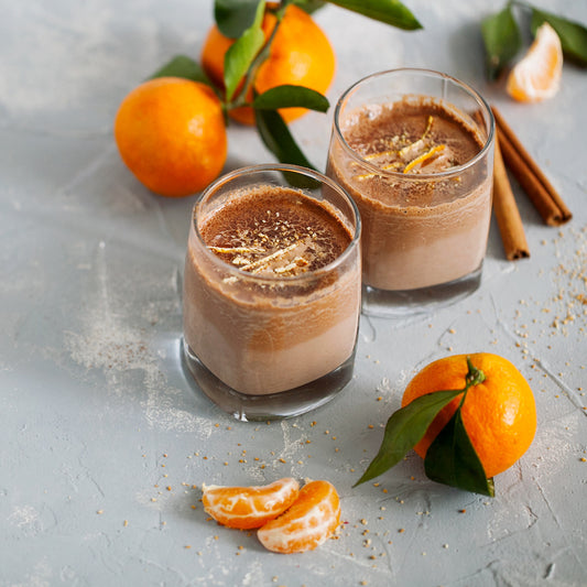 Pasolivo Hot Cocoa with Tangerine Olive Oil Recipe on a countertop next to tangerines and cinnamon sticks