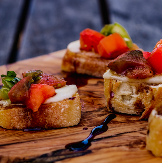 Heirloom Tomato Bruschetta Recipe plated on wooden cutting board