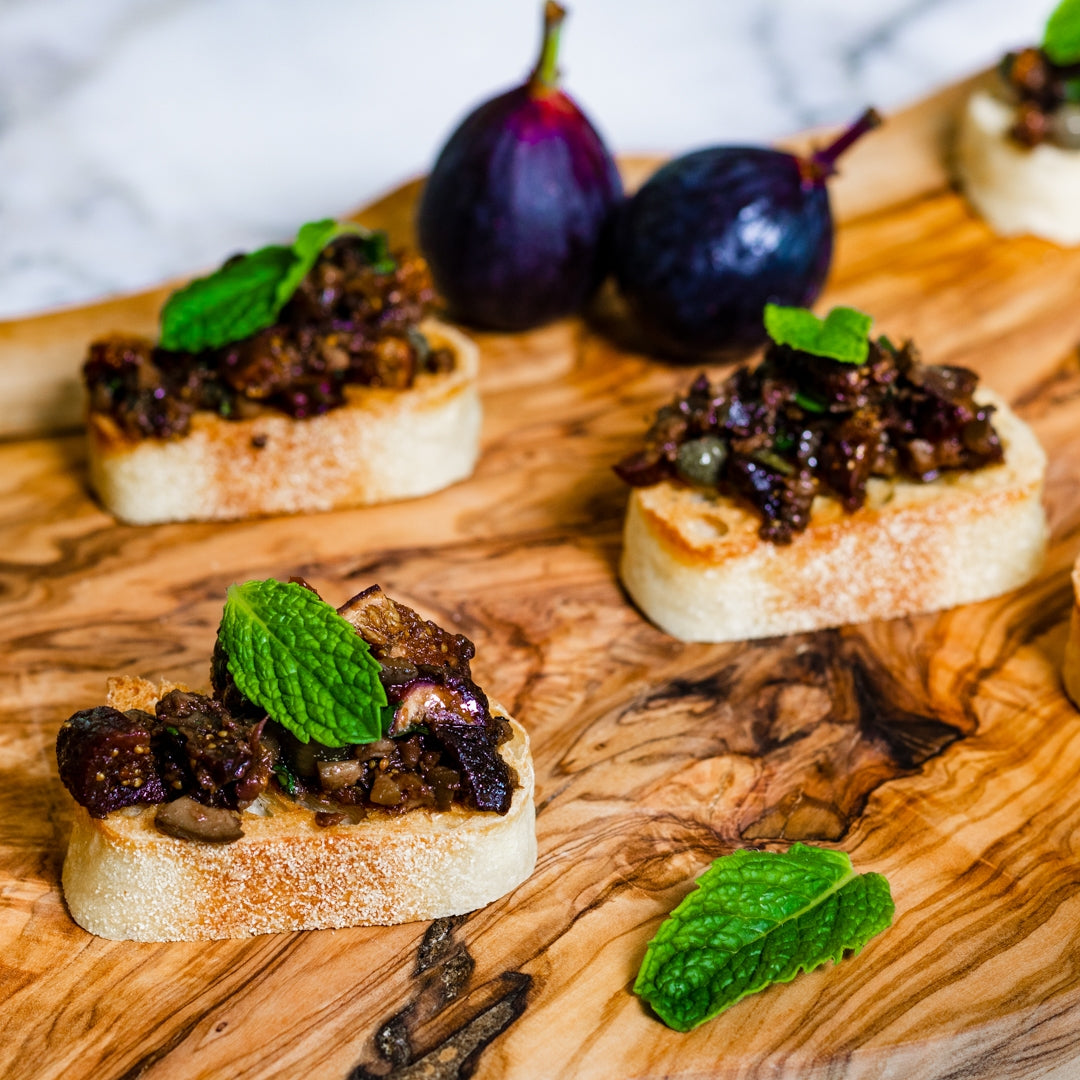 Pasolivo Tapenade & Figs Recipe next to fresh figs and garnished with mint