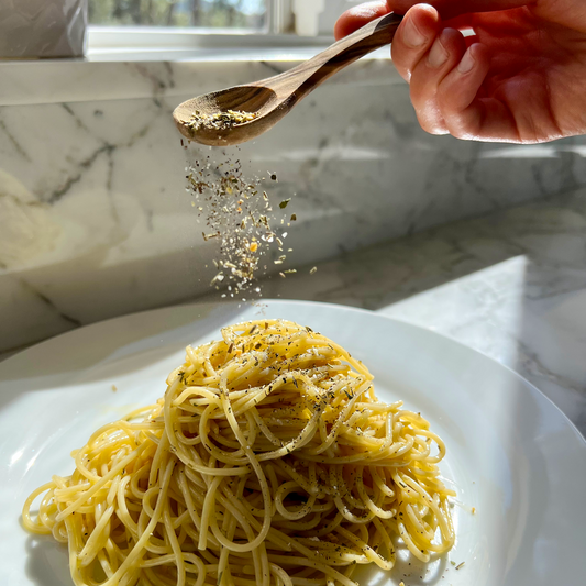 Pasolivo Simple Italian Pasta Recipe being garnished with Pasolivo Herbs