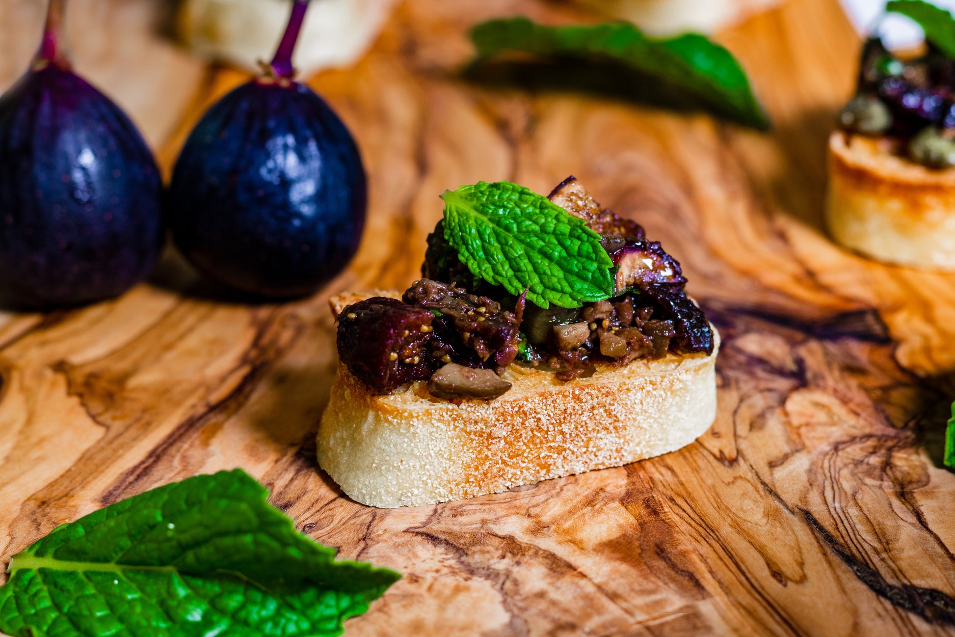 Pasolivo Tapenade & Figs Recipe next to fresh figs and garnished with mint