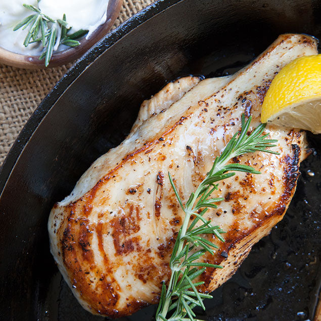 Pasolivo Yogurt & Citrus Olive Oil Chicken Recipe garnished with rosemary and a lemon wedge 